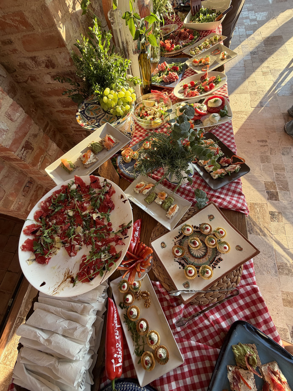 Masă cu antipasti: carpaccio, tartelete și bruschete